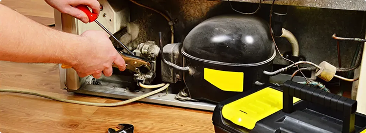 Refrigerator repair technician fixing the compressor and wiring in Hanahan, SC