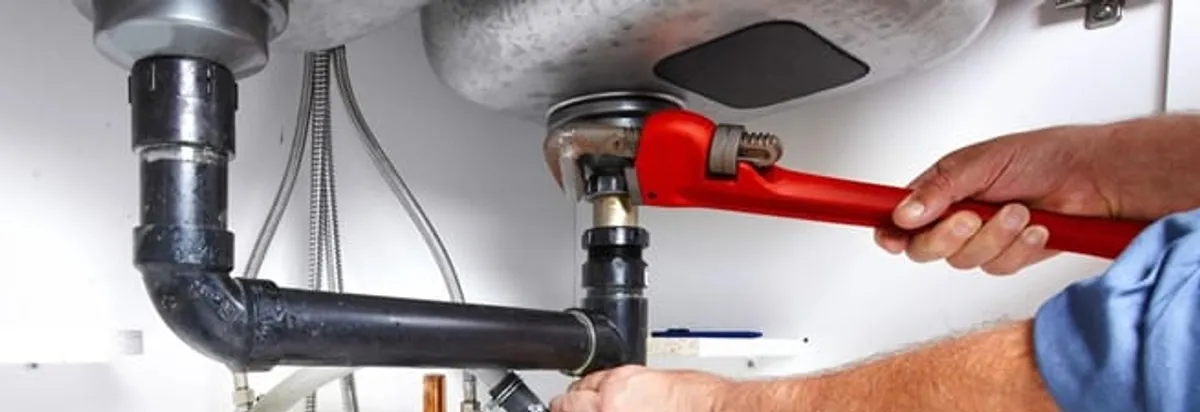 Garbage disposal repair technician tightening the sink drain and disposal connection in Charleston, SC